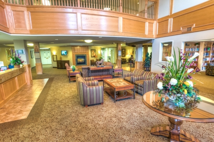 A welcoming common area features comfortable seating, vibrant flowers, and a warm, inviting atmosphere.