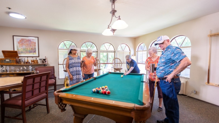 A vibrant group enjoys a friendly game of pool, fostering connection and laughter in a welcoming space.