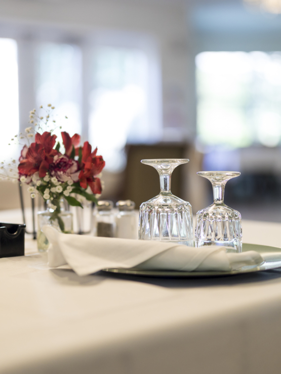 A beautifully set table with elegant glassware and fresh flowers, inviting warmth and community.