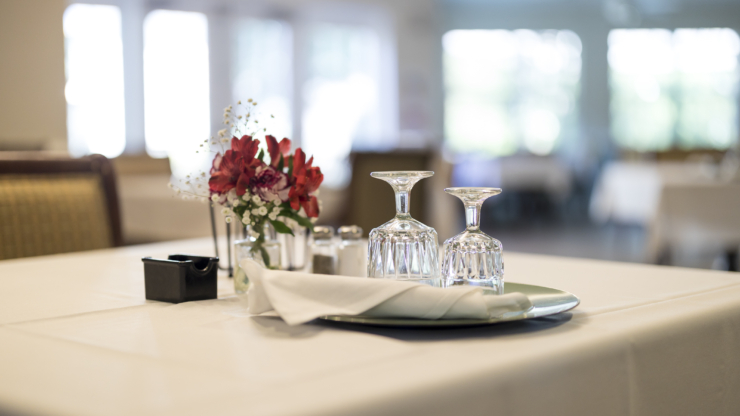 A beautifully set table with elegant glassware and fresh flowers, inviting warmth and community.