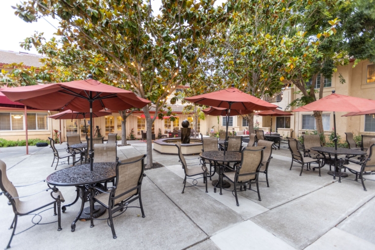 A welcoming courtyard with shaded tables invites relaxation and community gatherings.