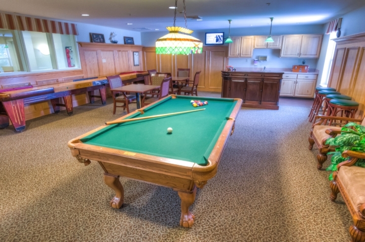 A welcoming game room featuring a pool table, inviting seating, and a warm atmosphere for socializing.
