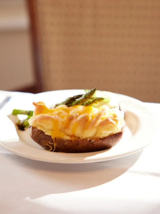 A beautifully plated meal accompanied by a glass of wine, inviting warmth and community spirit.