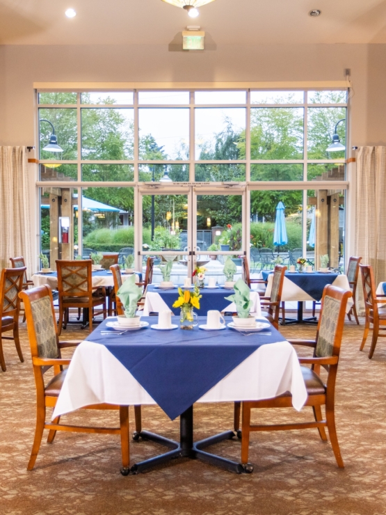 Bright and inviting dining area, filled with cheerful decor and views of a lush garden, fostering community.