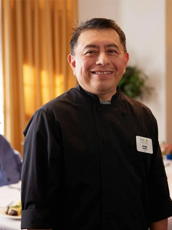 A warm dining atmosphere where residents enjoy meals, complemented by friendly staff engagement.