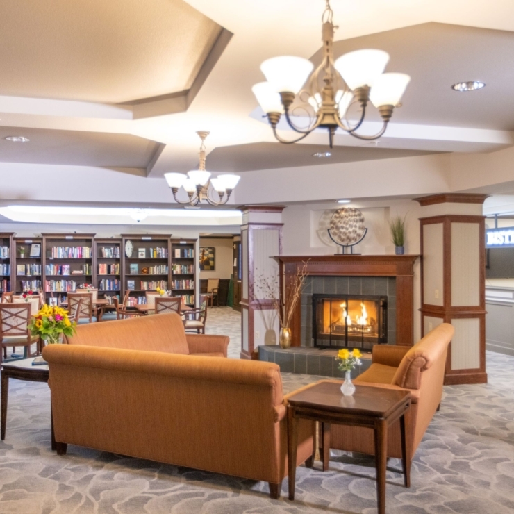 A warm and inviting lounge, featuring comfortable seating, a fireplace, and a welcoming library.