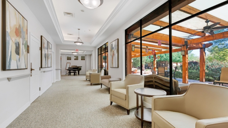 Bright, inviting space with comfortable seating, artful decor, and serene outdoor views fosters community.