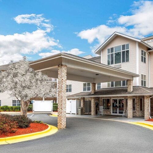 A welcoming entrance surrounded by blooming trees and vibrant landscaping, inviting community spirit.