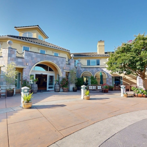 A welcoming entrance surrounded by vibrant plants and comfortable seating, radiating warmth and community.