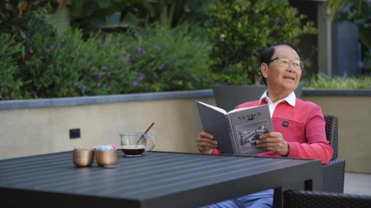 A warm, inviting outdoor space where residents enjoy leisurely moments with a good book and coffee.