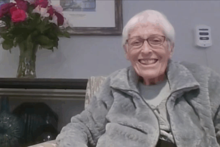 A joyful resident smiles warmly in a welcoming, beautifully decorated environment.