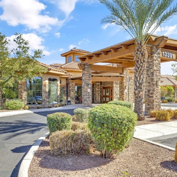 A welcoming entrance with lush greenery and warm architecture, inviting residents into a vibrant community.