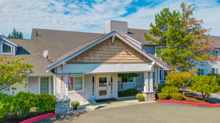 A welcoming entrance surrounded by lush greenery, inviting residents to a warm community atmosphere.
