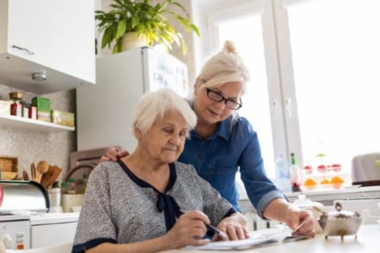 A warm, inviting moment in a bright kitchen, showcasing a nurturing bond between two women enjoying shared activities.