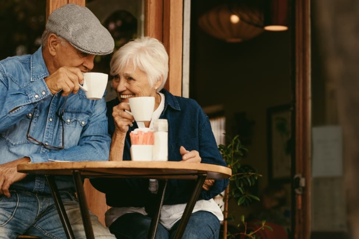 A joyful couple shares laughter over coffee, enjoying a serene moment in a vibrant café.
