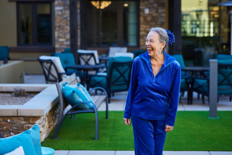 A joyful resident strolls through a vibrant courtyard, embodying warmth and community spirit.