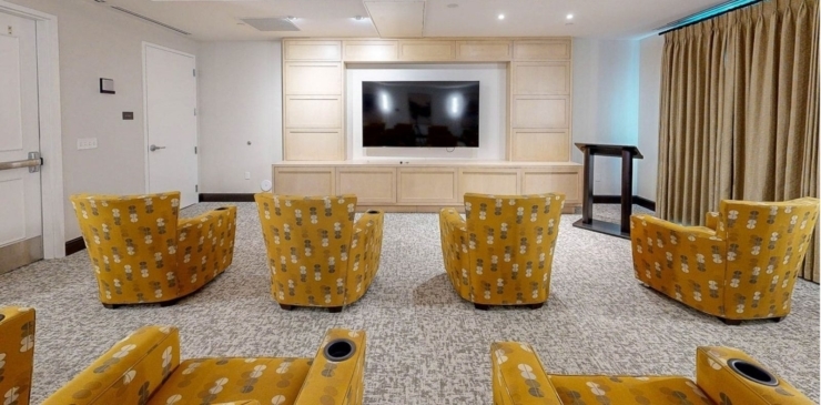 A welcoming lounge area with vibrant chairs and a large TV, perfect for community gatherings and relaxation.