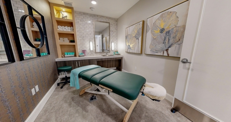A serene therapy room featuring a massage table, inviting decor, and a warm, welcoming atmosphere.