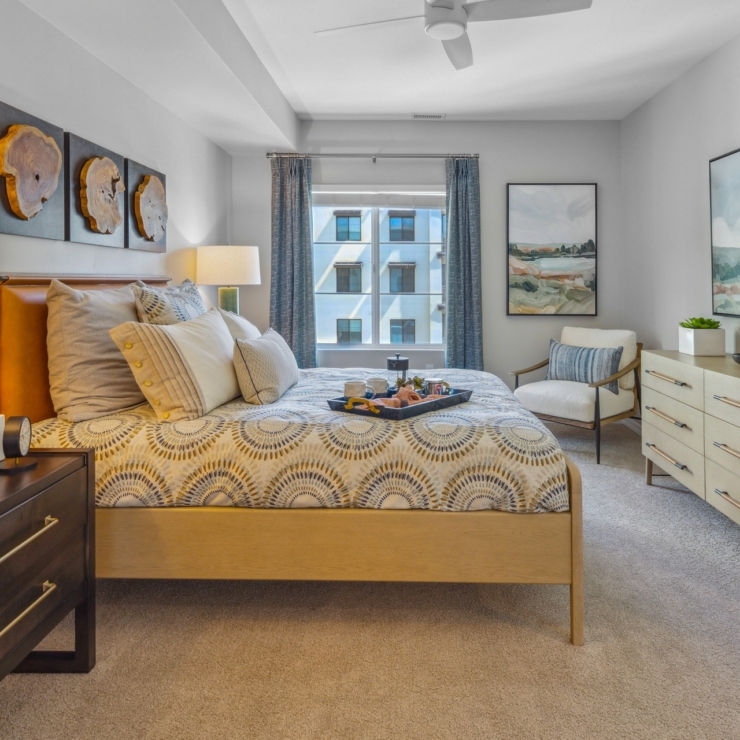 A welcoming bedroom filled with light, featuring elegant decor and a comfortable atmosphere for relaxation.