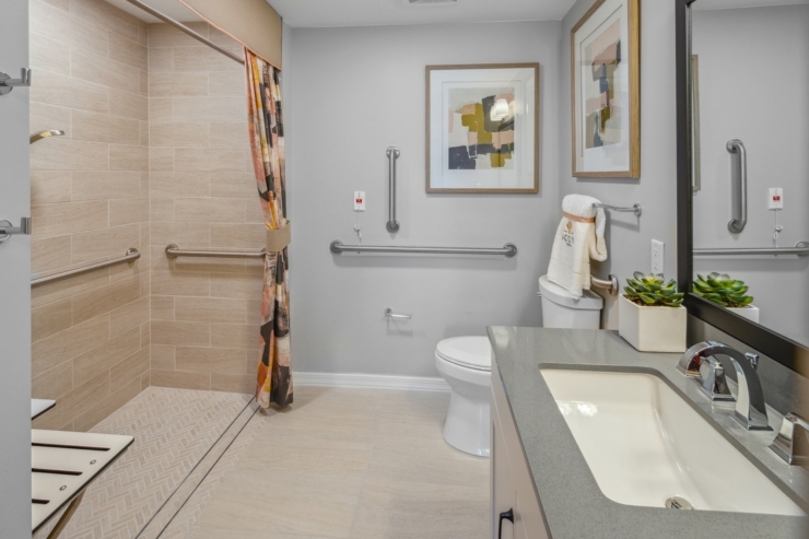 A bright, accessible bathroom featuring warm tones, modern fixtures, and thoughtful details for comfort.