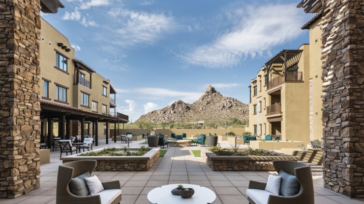 A serene outdoor space with cozy seating, surrounded by beautiful landscaping and stunning mountain views.