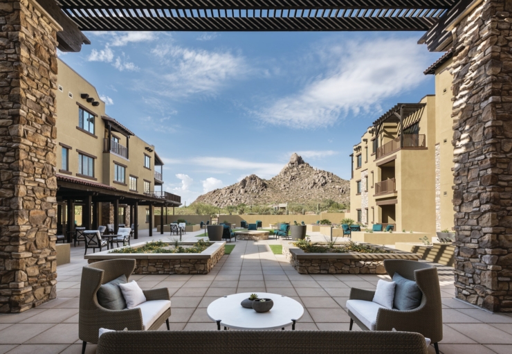 A serene outdoor space with cozy seating, surrounded by beautiful landscaping and stunning mountain views.
