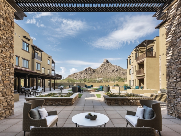 A serene outdoor space with cozy seating, surrounded by beautiful landscaping and stunning mountain views.