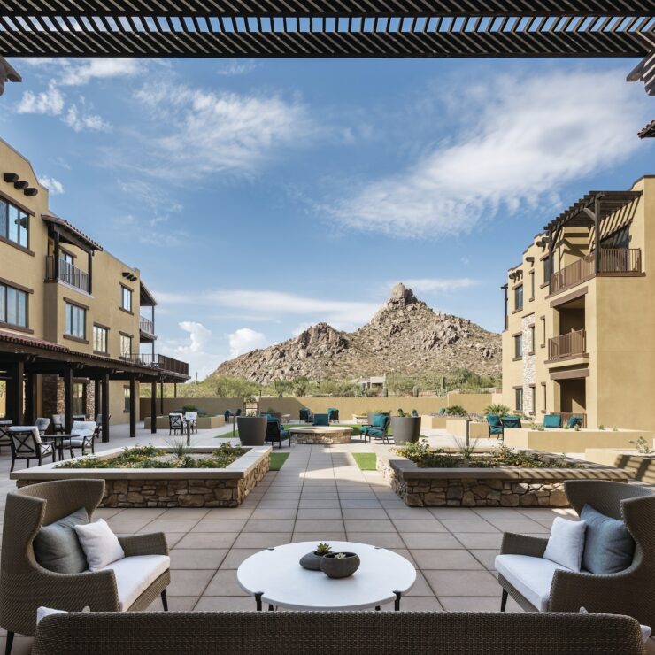 A serene outdoor space with cozy seating, surrounded by beautiful landscaping and stunning mountain views.