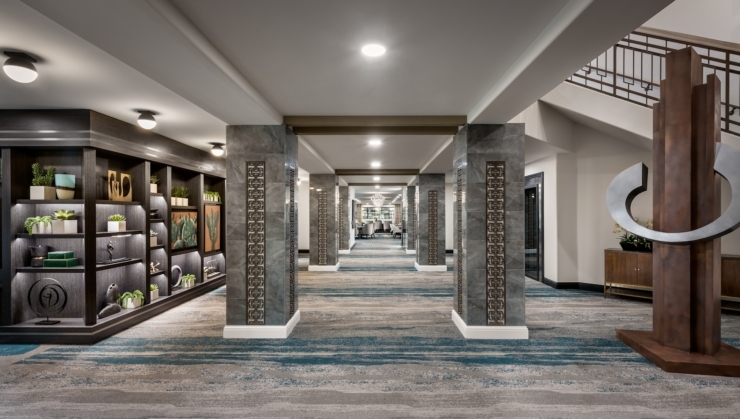 Bright, inviting hallways adorned with art and greenery foster a welcoming community atmosphere.