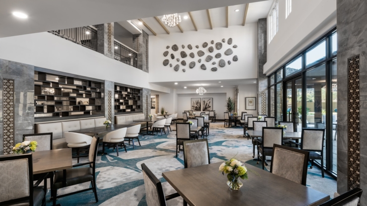 Modern dining area bathed in natural light, fostering community spirit and comfort through tasteful design.