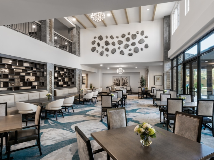 Modern dining area bathed in natural light, fostering community spirit and comfort through tasteful design.