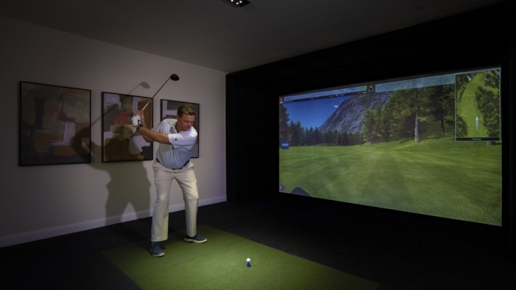 Engaging in indoor golf, residents enjoy a lively activity in a welcoming, vibrant setting.