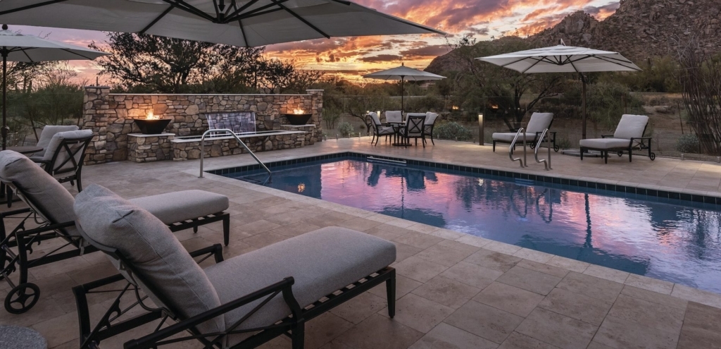 Tranquil outdoor space featuring a serene pool, inviting seating, and a stunning sunset backdrop.