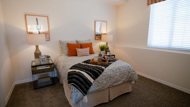 A serene bedroom featuring warm decor, inviting textures, and natural light, perfect for relaxation.