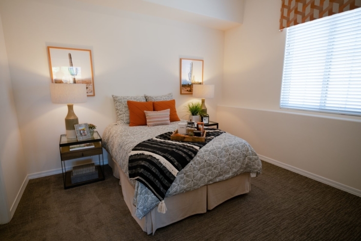 A serene bedroom featuring warm decor, inviting textures, and natural light, perfect for relaxation.