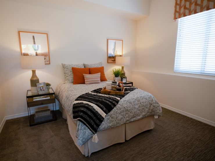 A serene bedroom featuring warm decor, inviting textures, and natural light, perfect for relaxation.