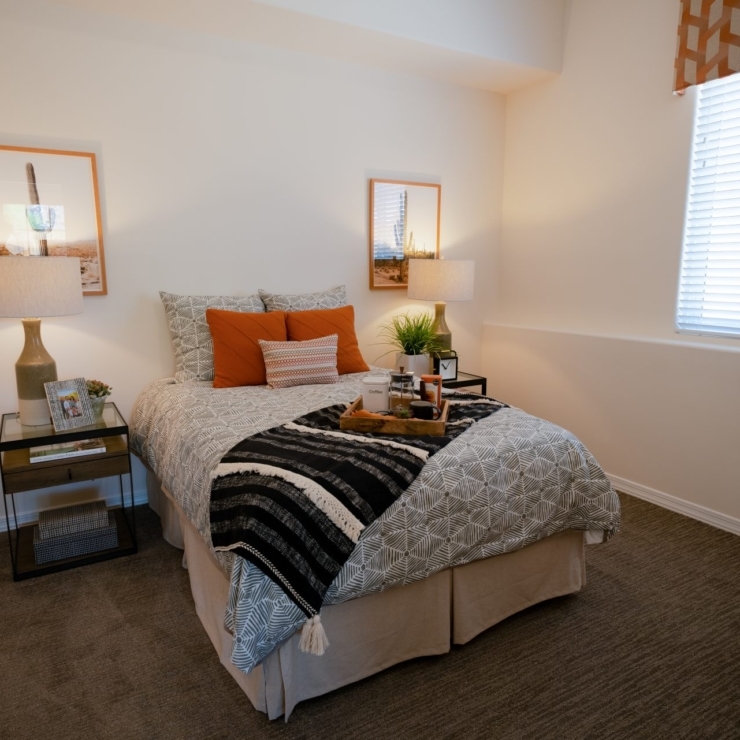 A serene bedroom featuring warm decor, inviting textures, and natural light, perfect for relaxation.