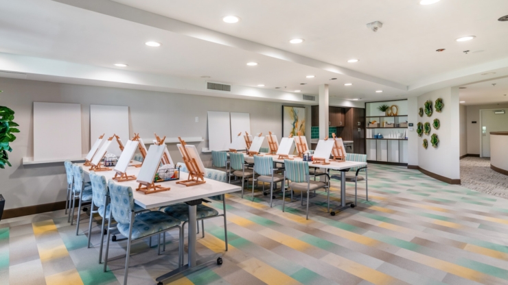 A welcoming art space filled with easels and cozy seating, perfect for fostering creativity and community.