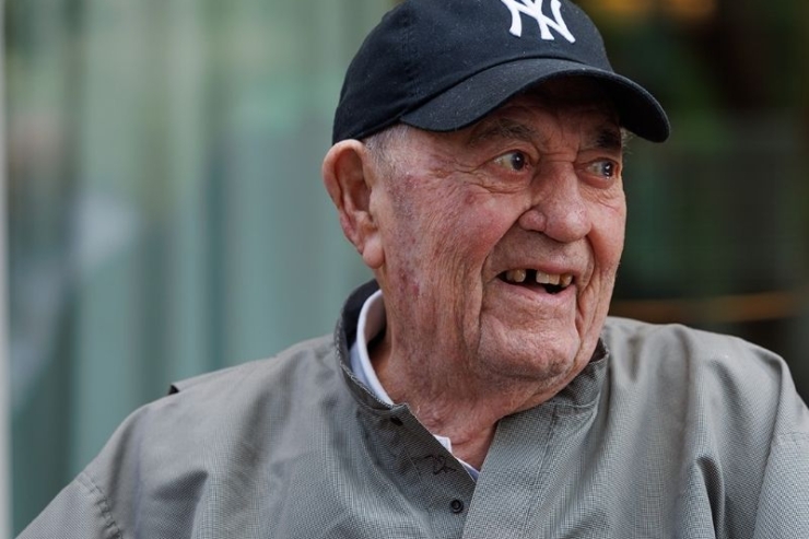 A smiling resident exudes warmth and joy, set against a serene backdrop of community life.