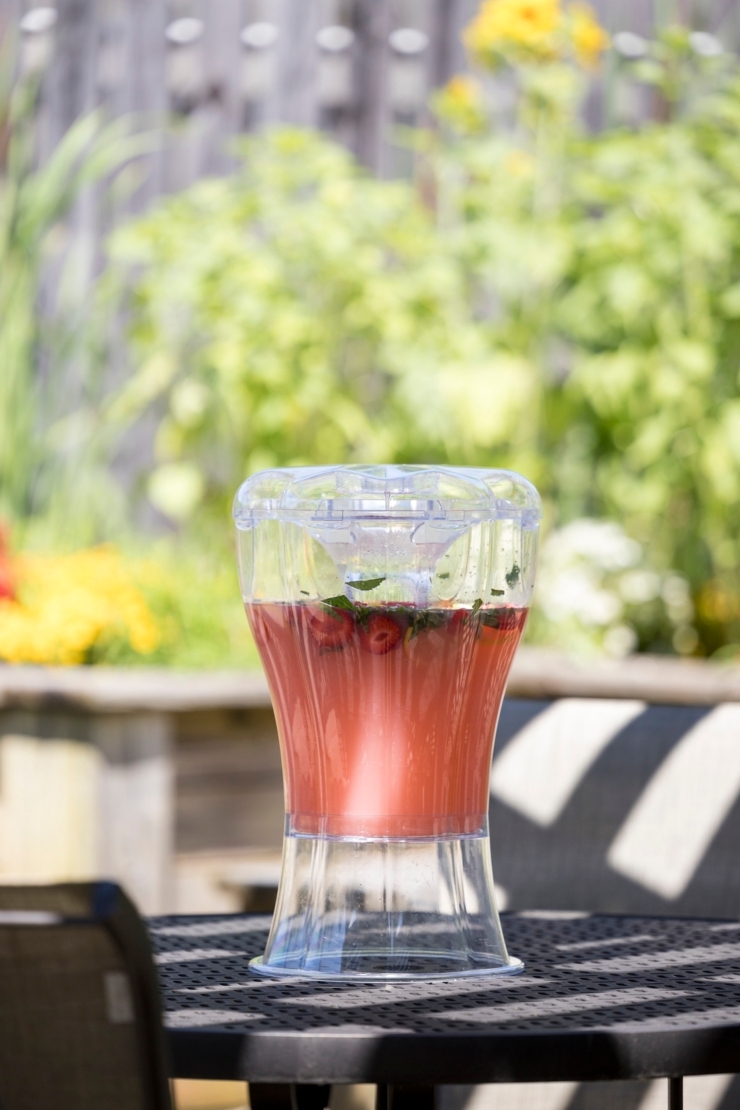 A refreshing beverage awaits on a sunny table, surrounded by vibrant flowers, inviting community gatherings.