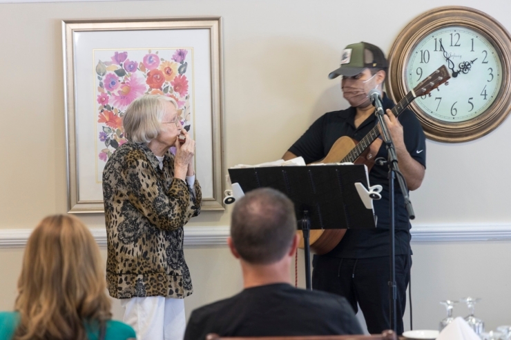 Residents enjoy a lively musical performance, fostering joy and connection in a warm, welcoming space.