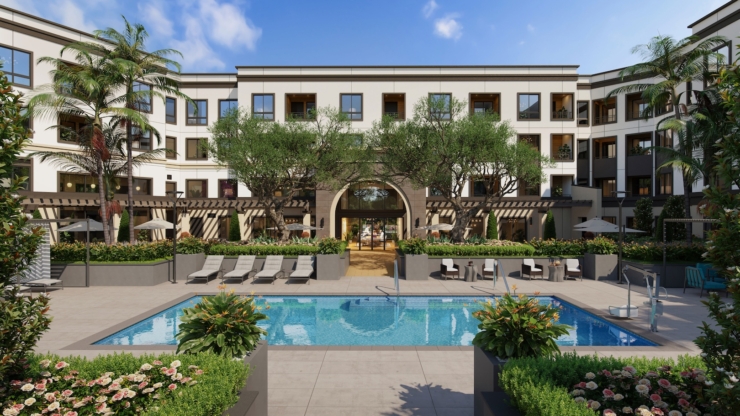 A welcoming courtyard features a serene pool surrounded by lush gardens, offering a peaceful retreat for residents.