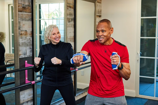 Two cheerful residents engage in an energetic workout, showcasing community spirit and active living.