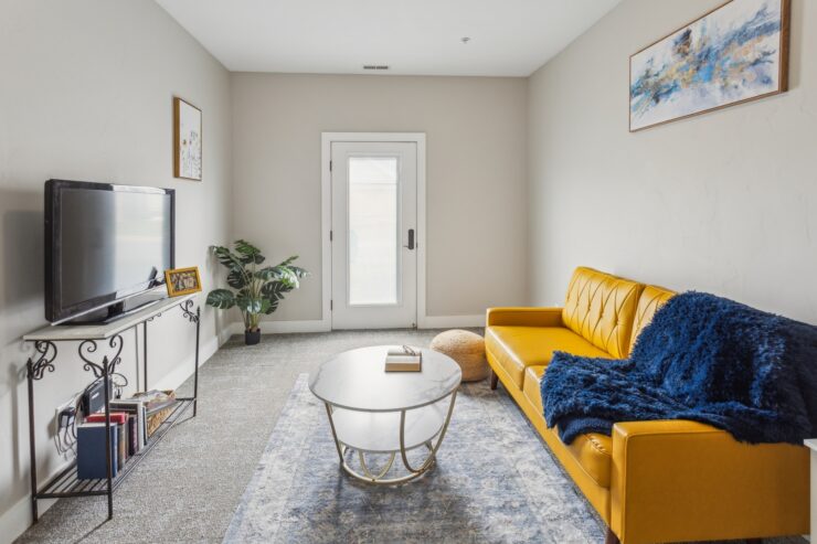 Bright and inviting space featuring a stylish yellow sofa, perfect for relaxation and connection.