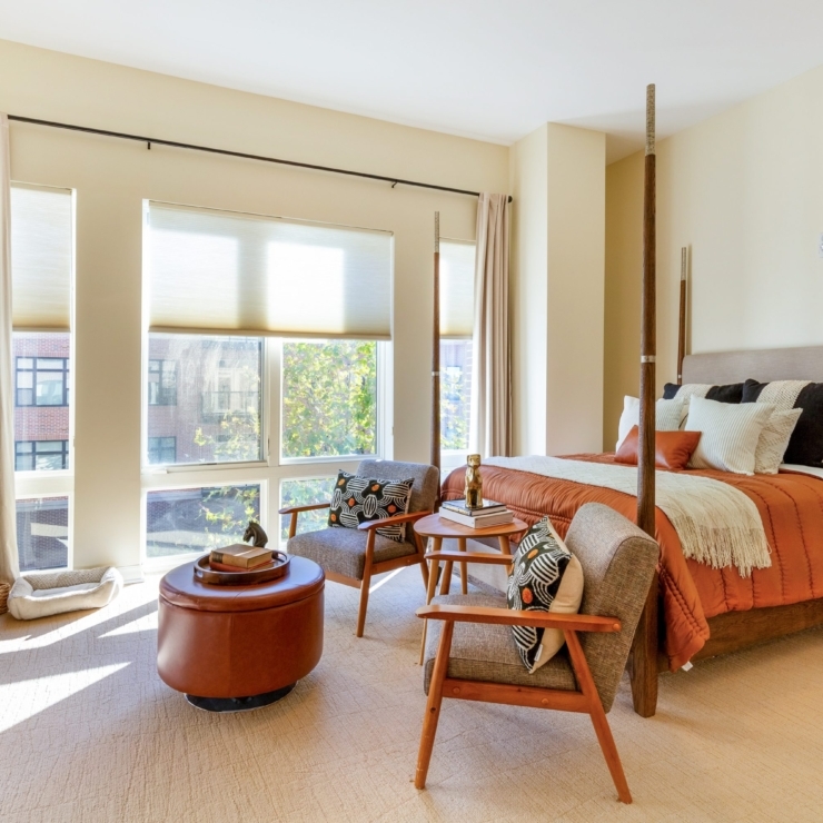 Bright and inviting, this spacious room features warm tones, comfortable seating, and large windows.