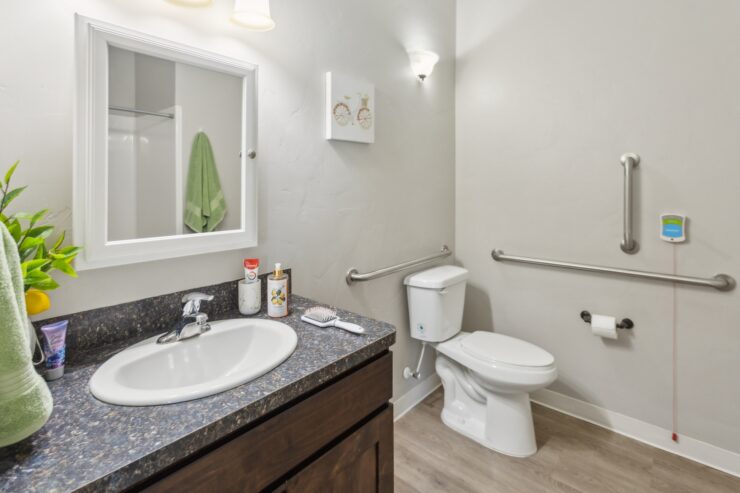 Bright and welcoming, this bathroom features accessible amenities and a touch of homey decor.