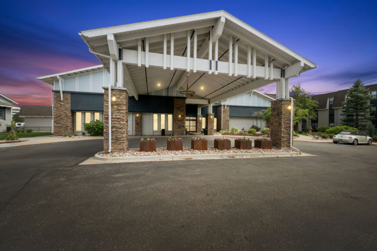 A welcoming entrance with vibrant flowers and warm lighting, inviting community and comfort.
