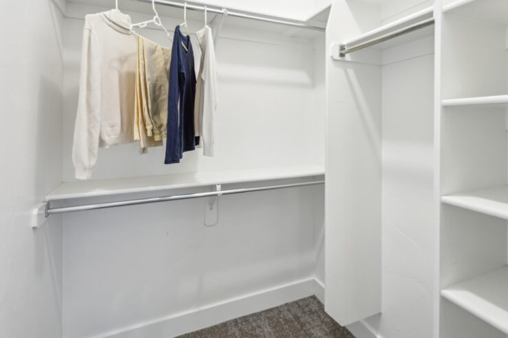 A bright, organized closet space, showcasing a welcoming atmosphere for personal belongings.