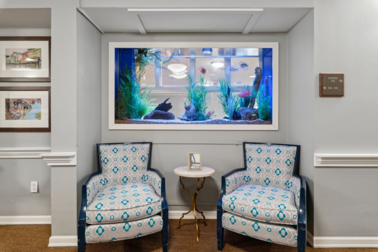 Bright, inviting space with charming chairs and a vibrant aquarium, fostering community and comfort.