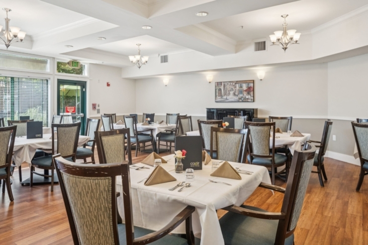 Bright, welcoming dining area filled with elegant tables, perfect for community gatherings and shared meals.